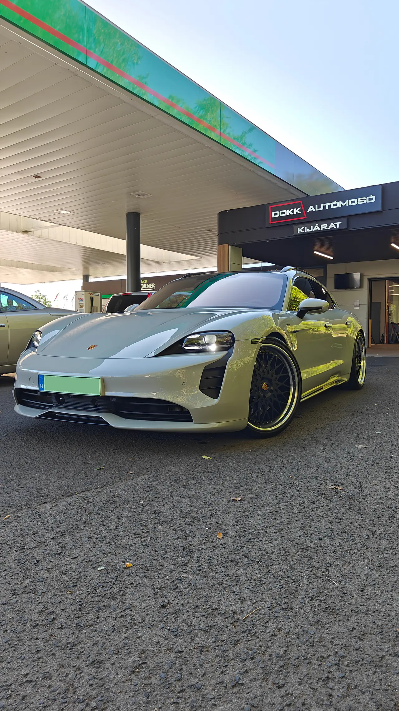 Világoszöld Porsche Taycan a DOKK Autómosó 2 kijárata alatt