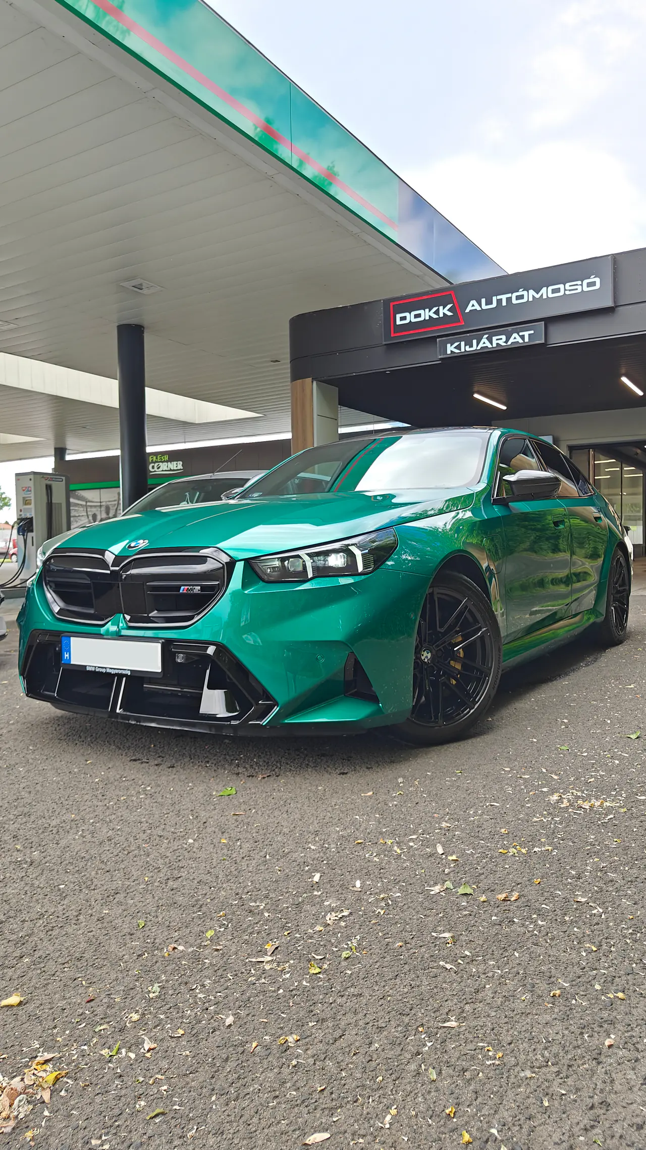 Smaragdzöld BMW M5 frissen mosva a mosó kijárata alatt